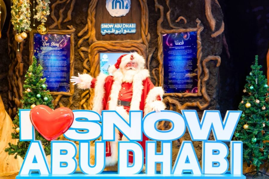 Santa Claus posing with a sign i love snow abu dhabi