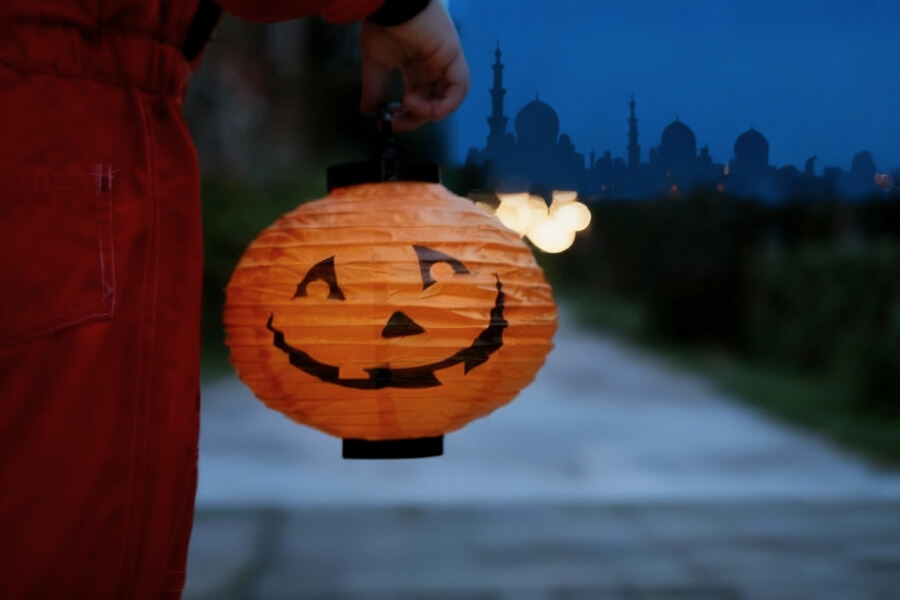 a child holding a lantern with sheikh zayed grand mosque in the background