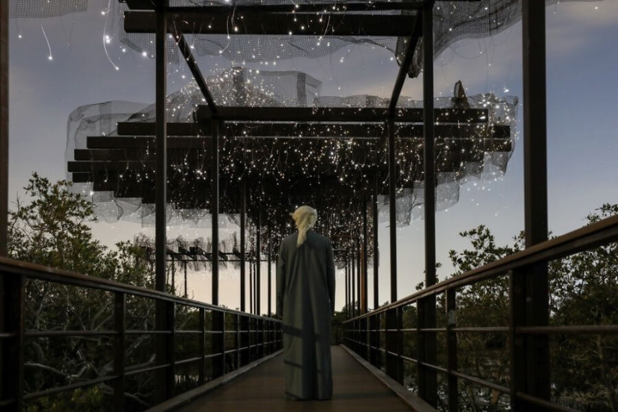 emirati man walking through tunnel of lights over mangroves manar abu dhabi art exhibition