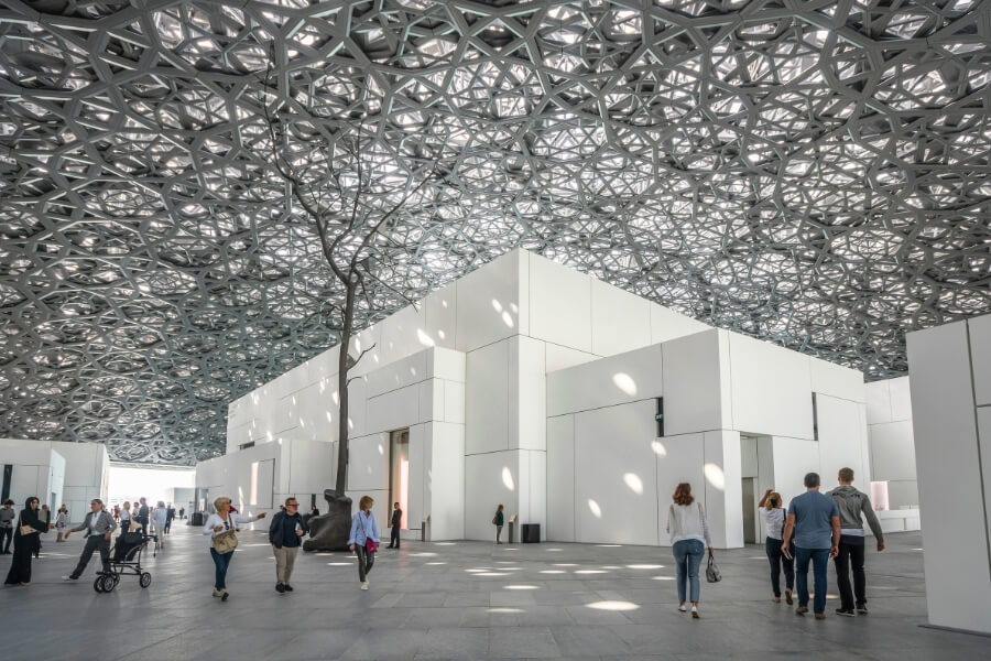 under the beautiful domed metal roof of the louvre abu dhabi